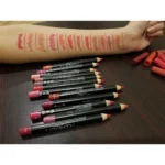 Flat lay of Huda Beauty eyeliner pencils in various shades, highlighting their creamy texture